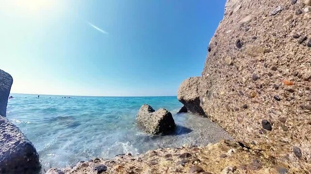 The horizon of the Mediterranean Sea under a blue sky framed by a group of rocks