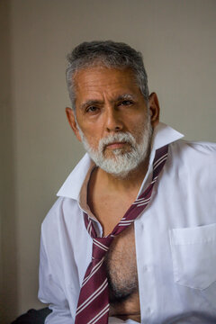 Mature Man in Loose Collar and Tie Looking at Camera