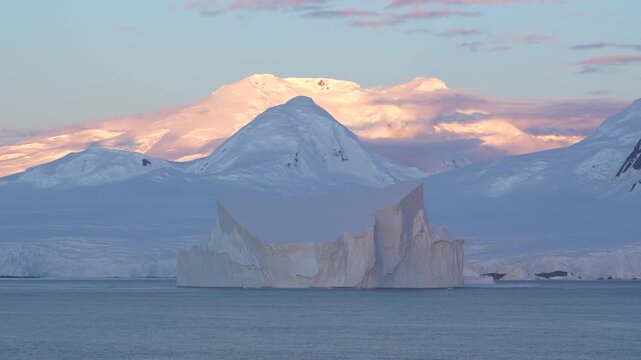 Antarctica Stunning Huge Tabular Iceberg at Sunset with Snow Covered Mountains Epic Remote Nature Destination. Incredible Massive Ice Floating