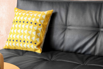 Fototapeta premium Home decor and interior design, yellow geometric pattern cushion on a black leather sofa, modern living room furniture