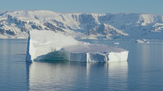 Antarctica Sailing Past Huge Tabular Iceberg with Beautiful Landscape of Mountains Covered in Snow, Ice, Glaciers Behind. Remote Nature Frozen Region