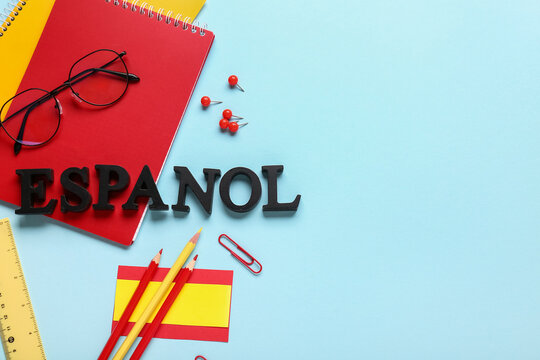 Spanish language learning and education concept espanol letters with notebooks pencils and flag on a blue background