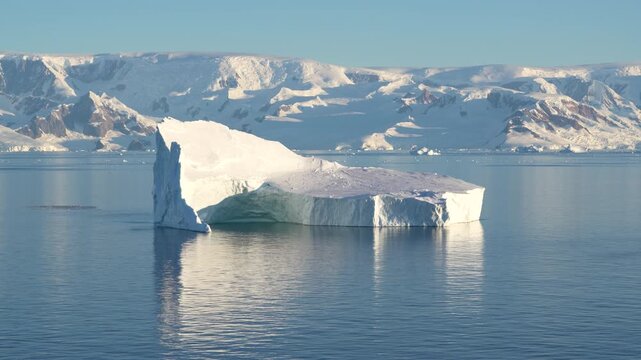 Antarctica Sailing By Huge Tabular Iceberg with Beautiful Landscape of Mountains Covered in Snow, Ice, Glaciers Behind. Remote Nature Frozen Region