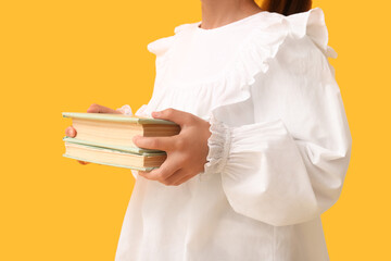 Naklejka premium Child with books on yellow background