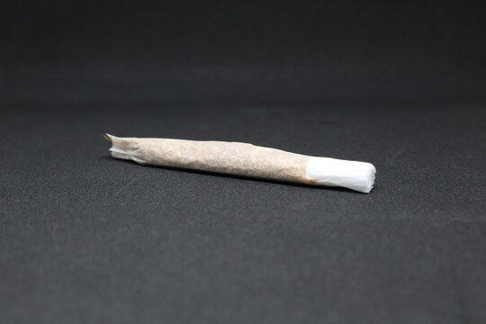 Rolled Tobacco Cigarette with Filter Tip on Dark Textured Background