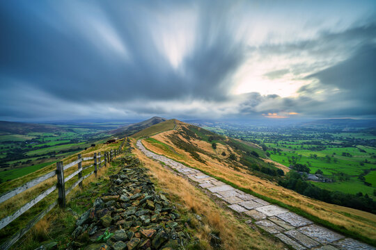 Stone footpath and wooden fence leading a long The Great Ridge in the English Peak District