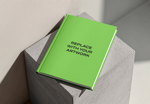 Hardcover book mockup with placeholder text resting on a concrete pedestal in studio setting, realistic presentation for graphic design, print media, Template, and editorial branding
