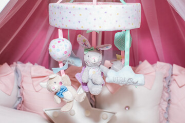Baby crib mobile with plush toys and colorful designs. Nursery decoration for newborn child comfort and calm sleep. Cute infant room decor. © Serg