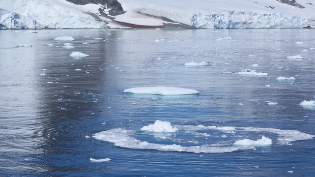 Iceberg Flipped Moving Ice in Antarctica. Moments After Tipped Ice the Water and Bits Float Away. View in Bismark Strait.