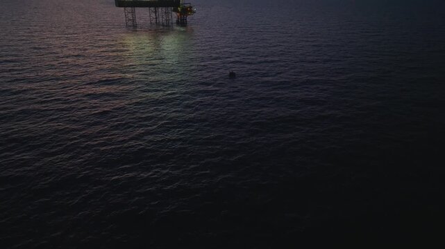 Aerial top view of offshore jack up rig and offshore platform during sunset for oil and gas exploration and production. 