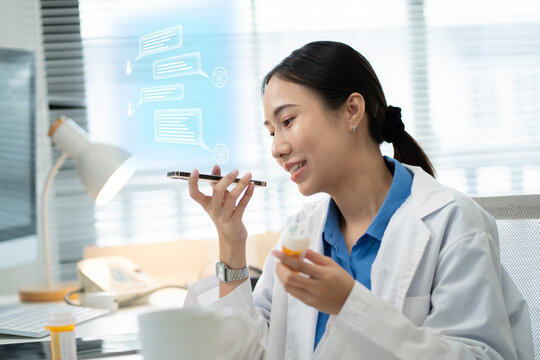 Asian female doctor using a smartphone in a hospital,interacting with a virtual assistant or AI chatbot.doctor reviews health data via ai agent,smart mirror technology,future technology