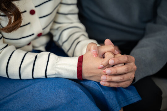 Young Asian couple sitting on sofa and talking with a professional therapist at clinic.Family therapy,Marriage,depression support,counselling,anxiety therapy,trauma advice,marriage help,mental health