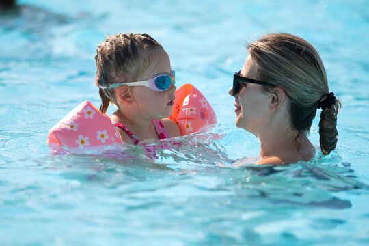 Happy Woman and Young Girl Having Fun in an Outdoor Swimming Pool