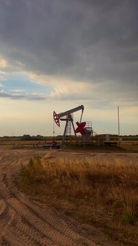 Oil extraction in oil field on sunset. Extraction of petroleum. Crude Oil Production. Crude pump jack working on oil field. Crude Pumpjack on sunrise. Industrial petroleum industry.