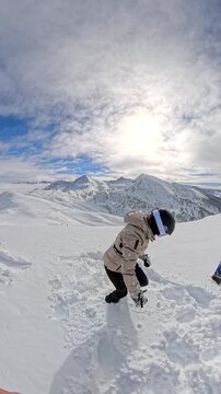 Woman playing in deep snow on a sunny mountain top