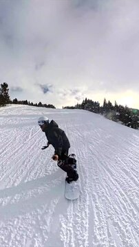 Snowboarder gliding down a snowy mountain slope