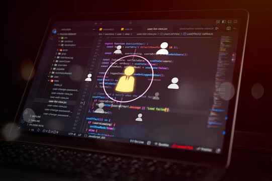User management and access control concept with programming code on laptop screen and digital user icons, representing account administration, permissions and software development.