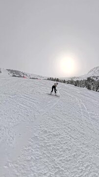 Woman snowboarding down a snowy mountain slope during winter vacation