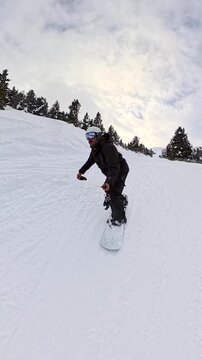 Snowboarder carving down a snowy mountain slope