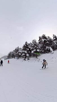 Woman snowboarding down a snowy mountain slope