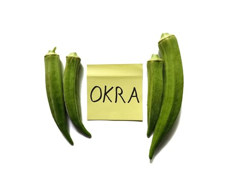 Fresh raw green okra Abelmoschus esculentus pods with handwritten note isolated on white background
