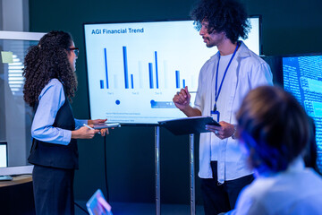 Cinematic shot of a diverse, multiethnic software team share findings with the seated team in a modern technology office bathed in blue light, showcasing a diverse, multiethnic (frame 626) © ultramansk