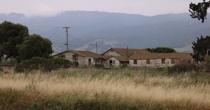 Cloudy daytime view of abandoned farm hand buildings near downtown Chualar, California, USA.