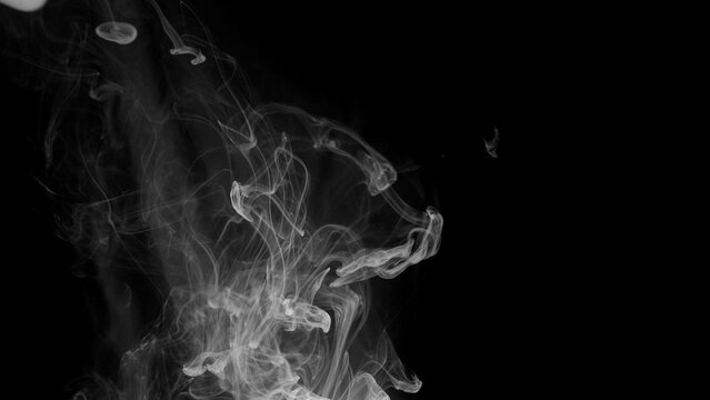 A single, dramatic explosion of white smoke bursts from the bottom of the frame against a stark black background.