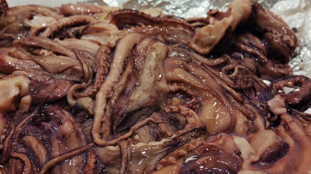Freshly caught raw calamari tentacles and body pieces creating an abstract texture, ready for cooking and preparing