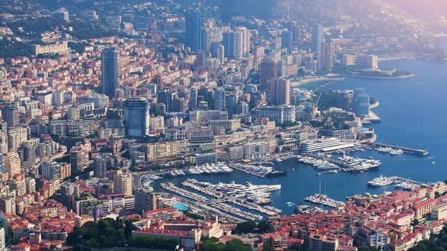 Monacos harbor is filled with yachts and boats while the skyline shows tall buildings and coastal views. This view captures the vibrancy of the city and its waterfront activities.