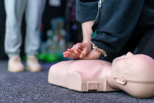 People practicing cardiopulmonary resuscitation CPR and basic life support techniques on a medical training manikin during a first aid course. Emergency response education and lifesaving skills.