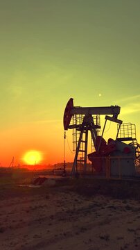 Oil extraction in oil field on sunset. Extraction of petroleum. Crude Oil Production. Crude pump jack working on oil field. Crude Pumpjack on sunrise. Industrial petroleum industry.