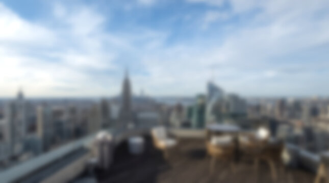 Blurry view of New York City skyline from rooftop terrace.