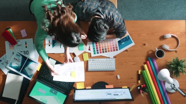 Top view of project manager looking at screen while designer writing idea. Close up of smart business team explain idea of logo design while designer choose theme while looking at palette. Symposium.