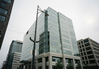 Naklejka premium Modern Glass Office Building Facade with Streetlight.