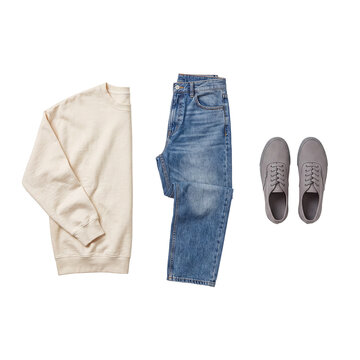 Casual attire ensemble featuring a cream sweatshirt, blue denim jeans, and gray canvas sneakers, minimalist flat lay.