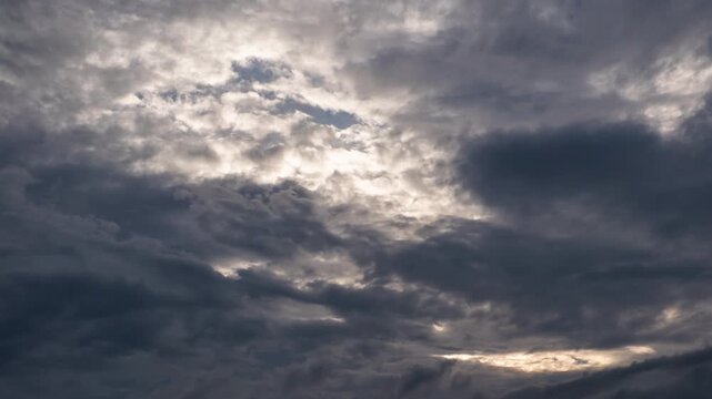 Ominous dark thunderclouds moving fast across the sky, impending rain storm time-lapse.