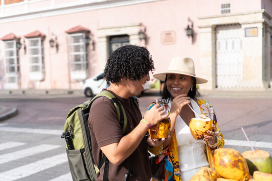 Tourists enjoying fresh coconut water on street vacation