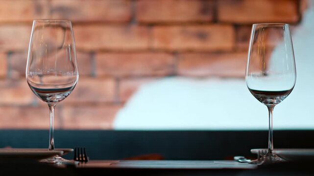 Elegant table setting with empty wine glasses in a modern restaurant interior.