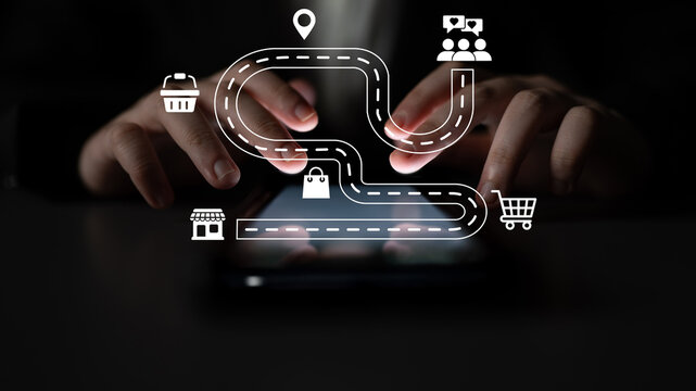 A creative visual of hands using a smartphone, featuring an illustrated road map with icons that represent various stages of the online shopping experience and digital marketing. Ledger
