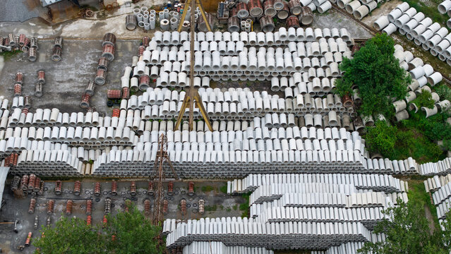 Aerial top‑down view of concrete pipe factory storage yard with industrial machinery