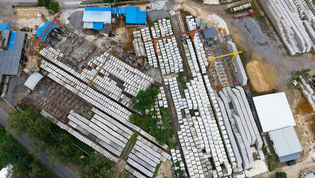 Aerial top‑down view of concrete pipe factory storage yard with industrial machinery