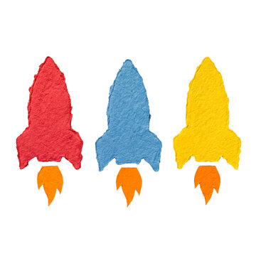 Three colorful, upward-pointing rockets crafted from textured torn paper, isolated on a transparent background.