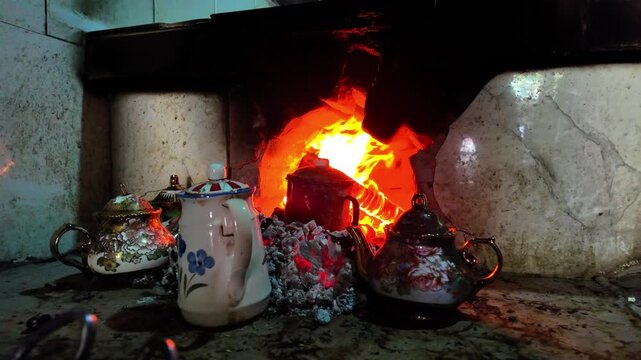 Traditional wood-fired stove and enamel teapots in a Shache teahouse