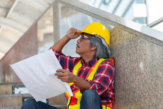 Confident Industrial Worker in Yellow Hardhat Teal Uniform Strong Professional Refinery Background