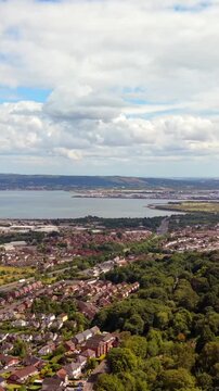 60FPS vertical social ratio aerial video of Belfast City from Cavehill in North Belfast, Northern Ireland in the UK on a bright sunny day. Produced with Rec709 colour.