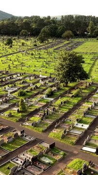 Overhead 60FPS vertical social ratio aerial video of Milltown Cemetary and the Republican Plot in West Belfast, Northern Ireland in the UK on a bright sunny day. Produced with Rec709 colour.