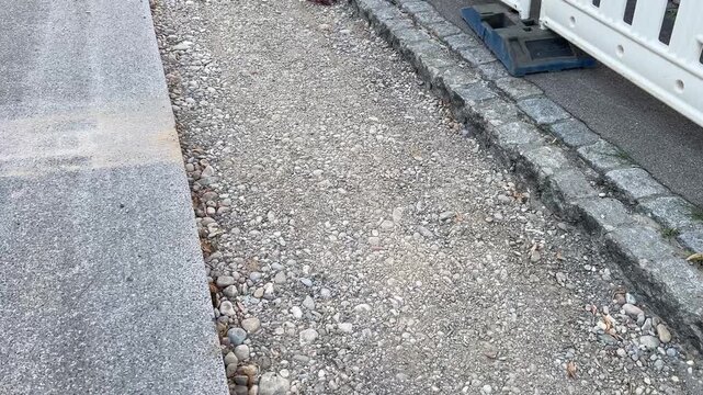 Slightly high angle into a backfilled district heating trench, filled with gravel while the sand and asphalt layers are still missing. A stage of utility groundwork and street reinstatement in Germany