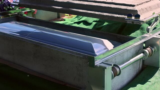 Coffin sits on stand covered with green fabric in memorial ceremony burial preparation