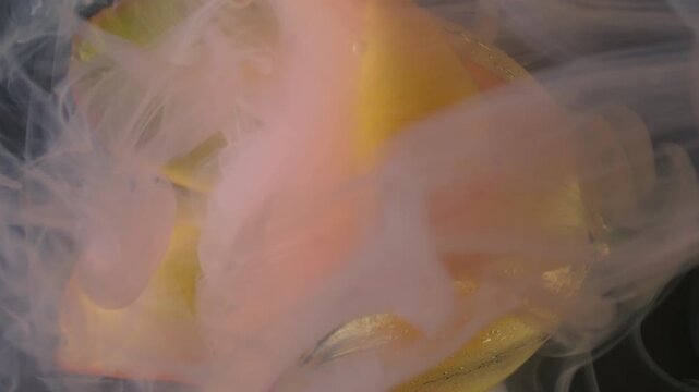 Vertical video. Flower water. Smoke ink. Defocused yellow color tulip plant nature droplet pink fog flowing on abstract art background.